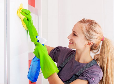 Oven cleaning technician using protective gloves and safe cleaning equipment